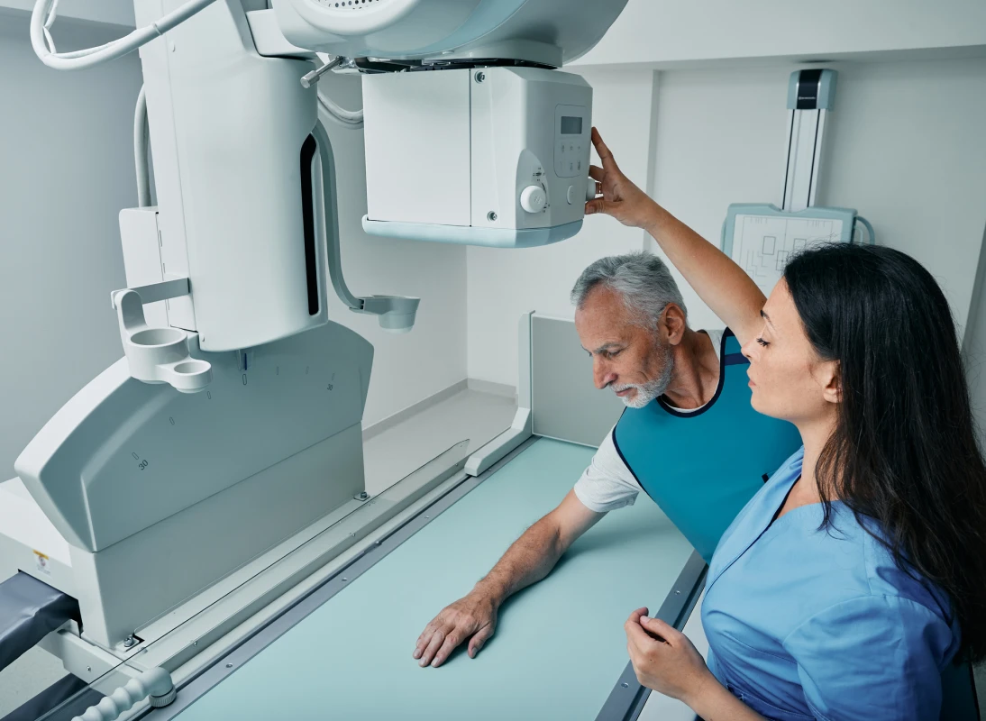 Technician adjusting X-ray machine for patient